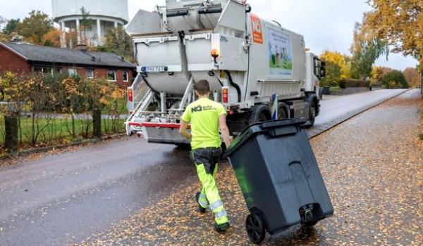 En sopåkare som ska tömma ett kärl i en sopbil