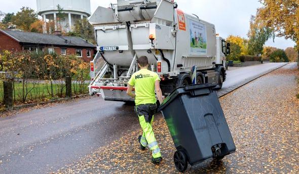 En sopåkare som ska tömma ett kärl i en sopbil